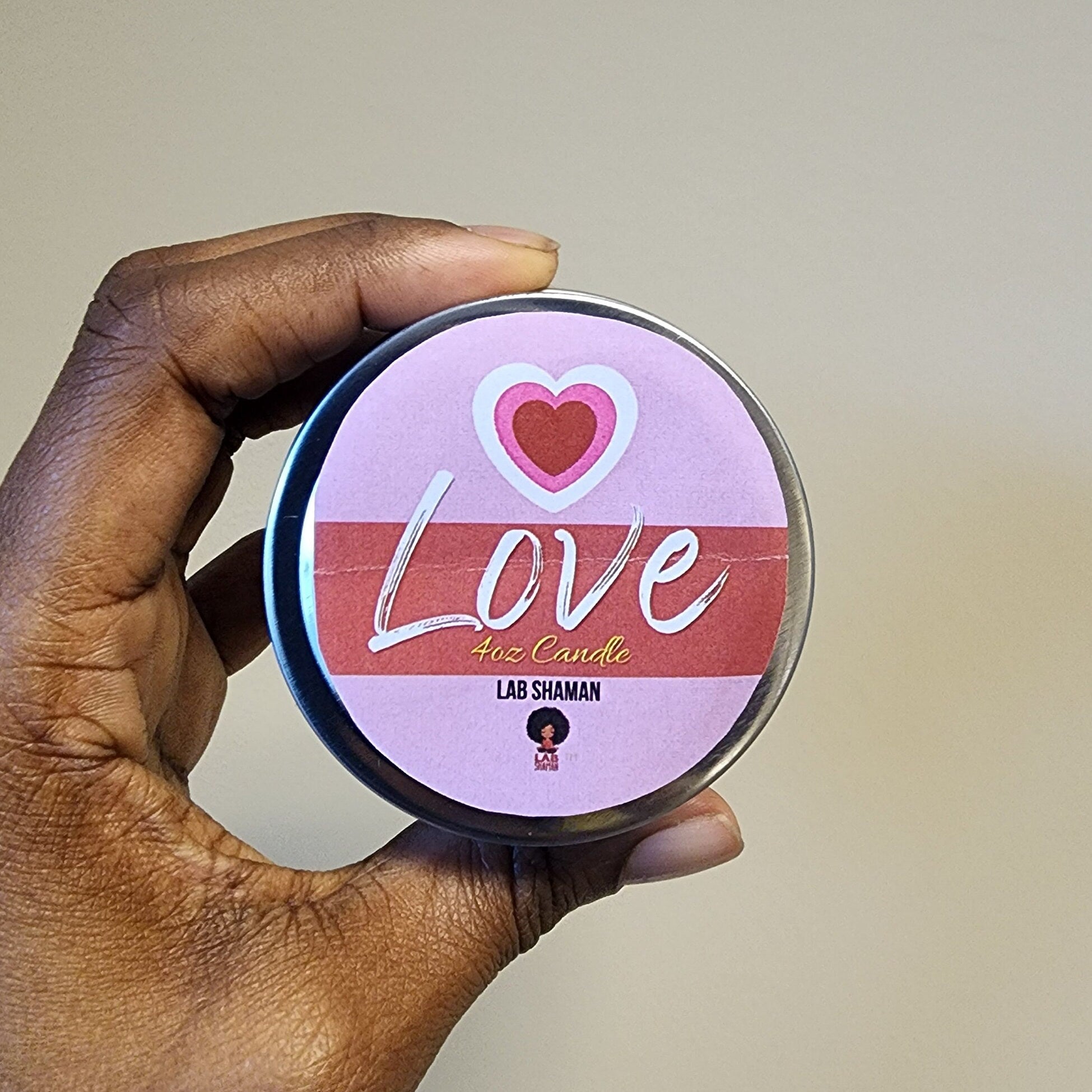 A radiant Love Candle infused with a warm, feminine aroma. It's adorned with an AB Rose Quartz and surrounded by over 20 hand-crushed herbs, symbolizing the universal forms of love this candle is meant to evoke, lab shaman