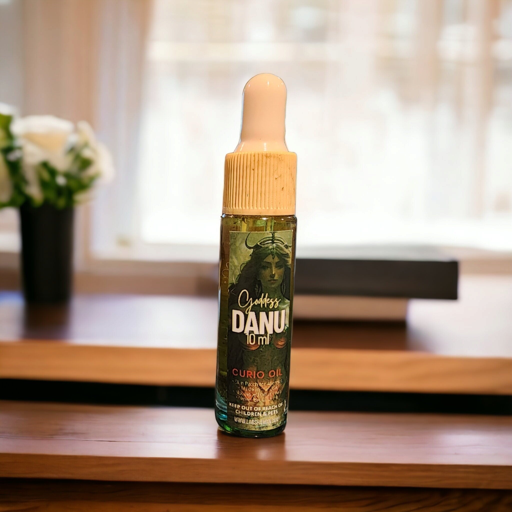 LAB Shaman's Danu Oil, encased in a glass vial, symbolizes fertility and abundance. With a clear green quartz, the oil reflects the essence of Danu, the Celtic Mother Goddess.